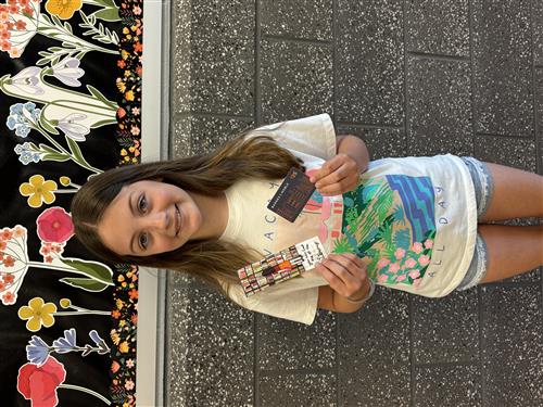 student smiling with gift card and bookmark